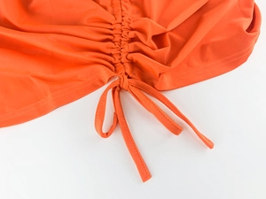 Détail du cordon réglable et texture froncée sur cette jupe d'été orange vif