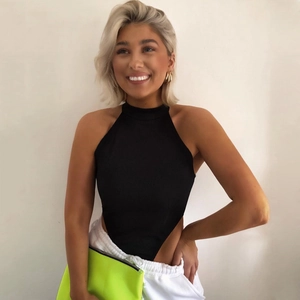 Détail d'un body licou noir en maille côtelée avec un sac à main vert fluo stylé