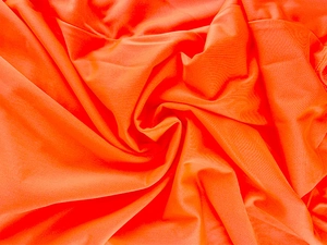 Détail du tissu orange vif avec texture à fines côtes et finition légèrement brillante