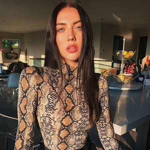 Detailed view of women's snakeskin print turtleneck bodysuit with long sleeves in sunlight