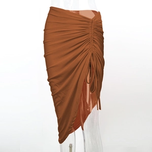 Détail de la jupe froncée caramel avec ourlet asymétrique et texture plissée élégante