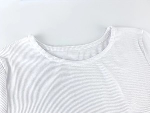 Close-up of white ribbed knit fabric texture and high-quality round neckline stitching