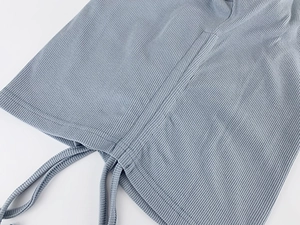 Macro view of slate blue ribbed knit fabric with adjustable drawstring and ruched side detail