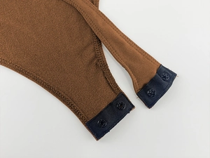 Détail de la fermeture à boutons-pression à l'entrejambe du body marron à manches longues
