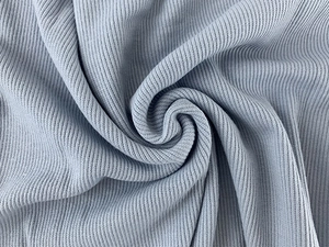 Macro shot of light blue ribbed knit fabric showing soft texture and vertical patterns