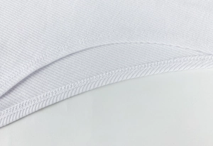 Close-up of white ribbed fabric texture and fine stitching detail on long sleeve bodysuit