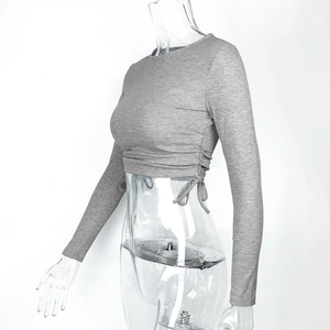 Detail view of the gray ribbed knit texture and adjustable side drawstrings on long sleeve crop top