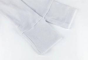 Detailed macro view showing the white ribbed knit texture on long sleeve cuffs