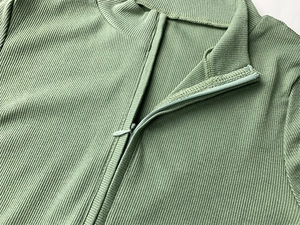 Détail du tissu en maille côtelée vert sauge et de la fermeture éclair du col montant