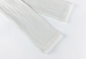 Gros plan détaillé montrant la texture en maille côtelée et les coutures des manches du body blanc
