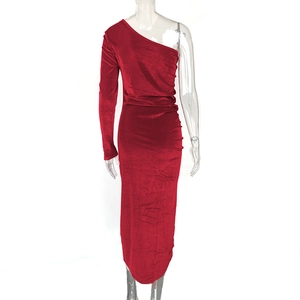 Detail of red velvet one-shoulder dress showing side slit and ruched texture