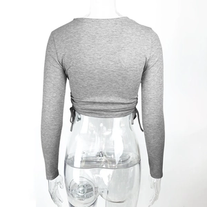 Detail of grey ribbed cropped top showing long sleeves and lace-up back design
