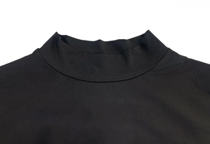 Dettaglio del collo alto del vestito nero con cuciture piatte e texture del tessuto pregiato