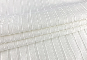 Vue macro d'un tissu en maille côtelée blanche avec des rayures verticales et parallèles