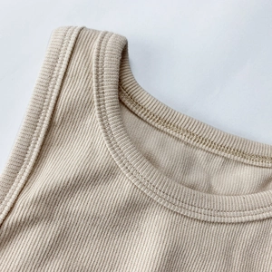 Gros plan sur le tissu en maille côtelée beige montrant les détails de couture soignés