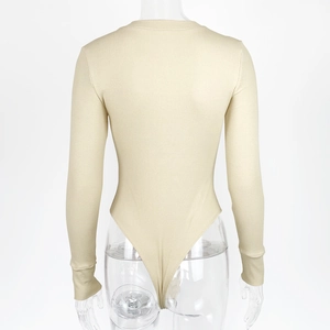 Detail view of the cream ribbed cotton bodysuit showing texture and long sleeve cuffs