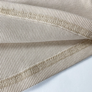 Gros plan sur la couture surjet double aiguille du tissu en coton côtelé beige