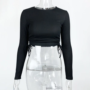 Detail of ribbed knit crop top featuring side drawstrings and adjustable gathered texture