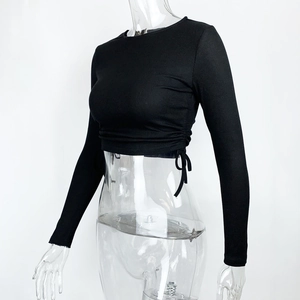 Detail of black ribbed knit crop top featuring adjustable side drawstring and crew neck