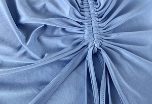 Macro view of blue silk fabric texture with drawstring ruched detail and fine stitching