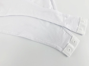 Detail view of the white bodysuit featuring a secure triple snap button closure at the crotch