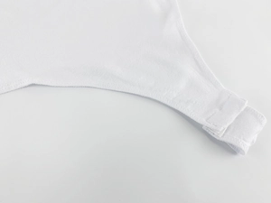 Macro detail of the crotch snap fastener on a white short sleeve bodysuit