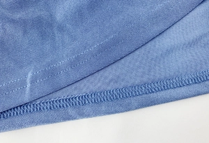 Detail of light blue knit dress hem with professional double-needle stitching and finish