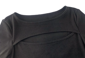 Détail d'un haut noir à manches longues en maille côtelée avec découpe sexy au torse