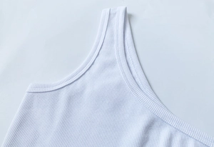 Dettaglio del tessuto a costine su un crop top bianco aderente senza maniche