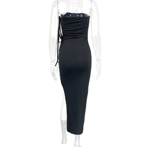 Detail of ruched side drawstring and high slit on a black bodycon tube dress