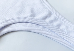 Dettaglio ravvicinato di maglia a coste bianca con cuciture a doppio ago di alta qualità