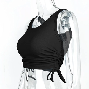 Detail of black ribbed crop top showing side adjustable drawstring ruching on a model