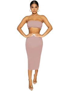 Dettaglio di un completo rosa a due pezzi con top a fascia e gonna longuette aderente