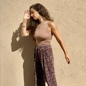 Outdoor shot of sleeveless camel crop top paired with leopard print wide leg pants
