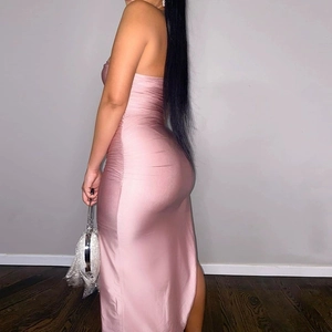 Detail view of the side ruching and satin fabric on the pink bodycon slit midi dress