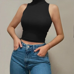 Detail of slim fit black sleeveless crop top with high neck paired with blue jeans