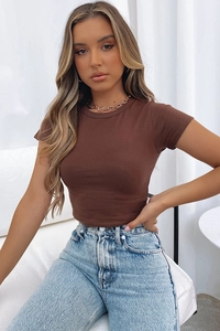 Close-up of slim-fit cropped brown T-shirt paired with high-waisted denim jeans