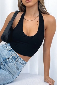 Detail of slim-fit halter top backless design paired with light blue high-waist jeans