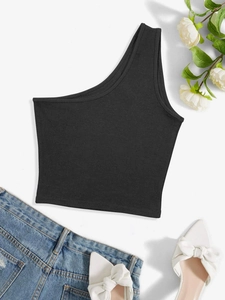 Dettaglio del crop top nero a coste monospalla con texture del tessuto e taglio asimmetrico