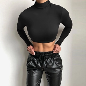 Detail view of high-neck black crop top and drawstring faux leather jogger pants
