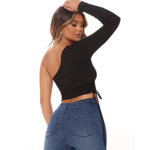 Detail of side drawstring and back cutout on slim-fit black one-shoulder long sleeve top