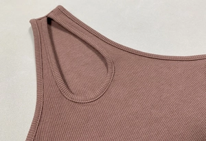 Dettaglio in maglia a coste color malva con ritaglio ovale e design monospalla