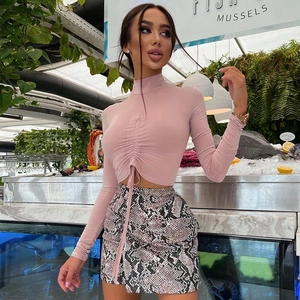 Detail of pink long sleeve crop top with ruched drawstring and python print skirt