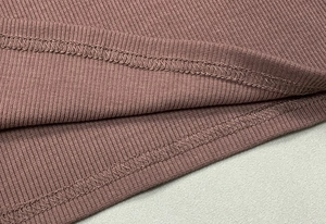 Dettaglio macro del tessuto a maglia a coste rosa antico con cucitura a doppio ago