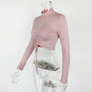 Close-up of pink long sleeve crop top with drawstring ruching and high neck detail