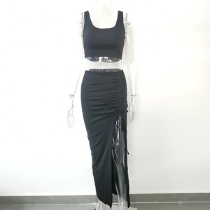 Detail of black two-piece set featuring a cropped tank top and side-slit ruched maxi skirt