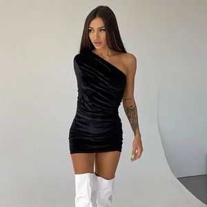 Détail du tissu en velours froncé noir et de la coupe asymétrique de cette robe ajustée