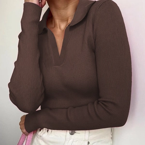 Detail of dark brown ribbed knit polo shirt with slim fit long sleeves and V-neckline