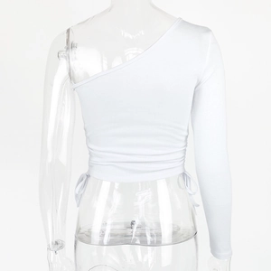 Detailed close-up of white one-shoulder crop top with side drawstring and ribbed knit fabric