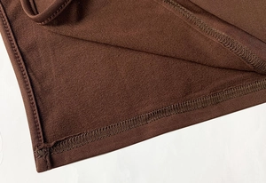 Detail of dark brown knit dress featuring warm fleece lining and neat overlock stitching